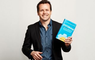 David Jenyns holding his book on SYSTEMology