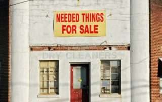 needed things for sale poster posted on white concrete establishment