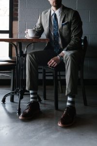 A well-dressed man enjoys a cup of coffee