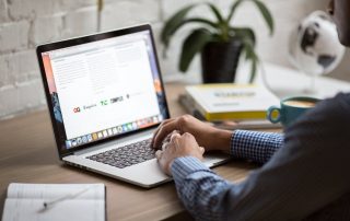 A man types on his laptop