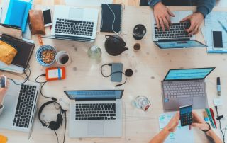 A group of people doing work on laptops